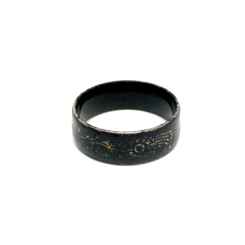 K&ouml;nnte beinhalten: Ein schwarzer Metallring mit einem dekorativen Design. Der Ring ist abgenutzt und hat einen Used-Look.