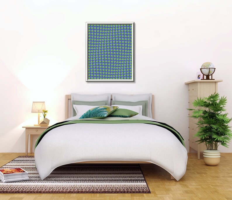 May include: A white bed with a green and white patterned throw blanket and two green pillows. A framed print with a blue and green pattern hangs above the bed. A wooden nightstand with a lamp and a small plant sits next to the bed. A wooden dresser with a globe and a plant sits on the right side of the image.