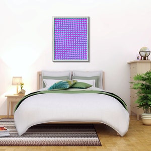 May include: A white bed with a green and white patterned bedspread and two pillows. A framed print with a blue and pink geometric pattern hangs above the bed. A lamp sits on a wooden nightstand next to the bed. A potted plant and a globe sit on a wooden dresser to the right of the bed.