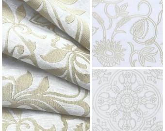 May include: Close-up of beige and white fabric with a floral pattern. The fabric is folded, showing the texture and design. Additional images show detailed floral and geometric patterns in beige on a white background, suitable for home decor.