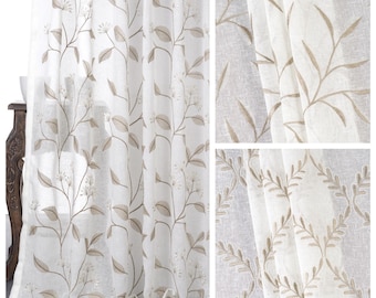 May include: White sheer curtains with a delicate embroidered floral pattern in a light brown color. The pattern features leaves and small flowers.