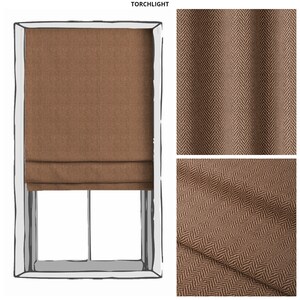 May include: A brown roman shade with a herringbone pattern. The shade is shown in a window with a white frame. The fabric is shown in a close-up view.