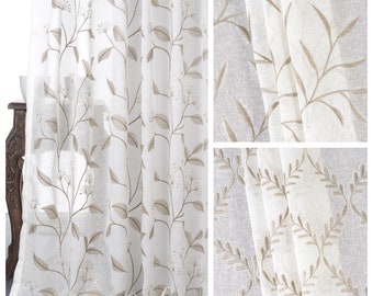May include: White sheer curtains with a delicate embroidered floral pattern in a light brown color. The pattern features leaves and small flowers.