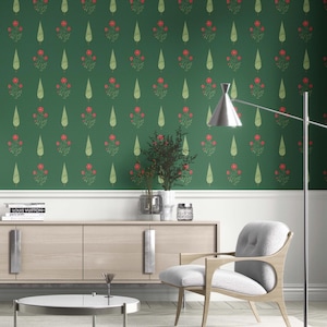 May include: Green wallpaper with a repeating pattern of red floral bouquets and teardrop shapes. The wallpaper is installed on a wall above a white baseboard. A modern living room is furnished with a light wood cabinet, a gray chair, and a silver lamp.