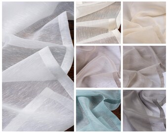 Könnte beinhalten: Eine Sammlung von durchsichtigen Stoffproben in verschiedenen Farben, darunter Weiß, Beige, Grau und Hellblau. Der Stoff hat eine subtile Textur und ein weiches, fließendes Gefühl.