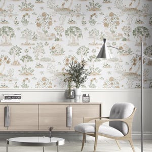 May include: Wallpaper depicting a whimsical forest scene with elephants, deer, and birds. The design incorporates trees and floral elements in shades of green, brown, and beige against a white background. The wallpaper is displayed in a room setting with modern furniture.
