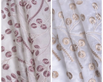 May include: Two pieces of sheer white fabric with embroidered floral designs. One fabric has pink embroidery and the other has gold embroidery.