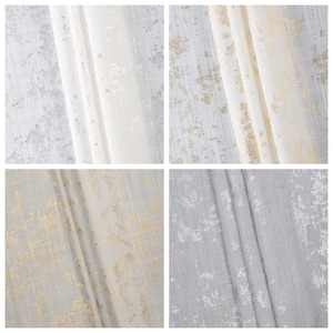 May include: Four fabric swatches with a subtle textured pattern. Two swatches are white with a gold metallic sheen, and two swatches are gray with a white metallic sheen.