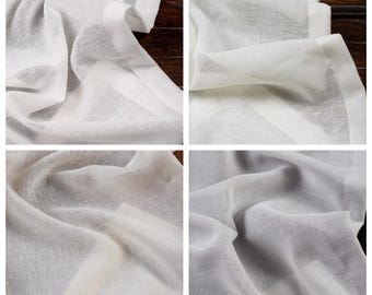 Puede incluir: Tela blanca transparente con una textura sutil. La tela está doblada y drapeada, mostrando su naturaleza suave y delicada.