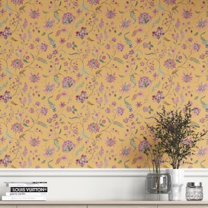 May include: Mustard yellow wallpaper with a repeating floral pattern in pink, purple, and green. The design features stylized flowers and leaves on winding stems. The wallpaper creates a vibrant and decorative backdrop, suitable for interior design projects.
