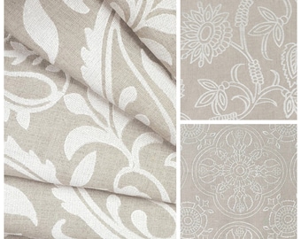 May include: Three fabric swatches featuring different white embroidered patterns on a beige background. The patterns include a floral design, a paisley design, and a geometric design.