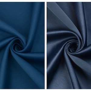 May include: Two swatches of blue satin fabric. The fabric on the left is a darker shade of blue, while the fabric on the right is a lighter shade of blue.