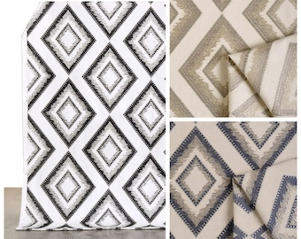 May include: Three fabric swatches with a geometric diamond pattern. The first swatch is white with black and gray diamonds. The second swatch is beige with brown diamonds. The third swatch is beige with blue diamonds.