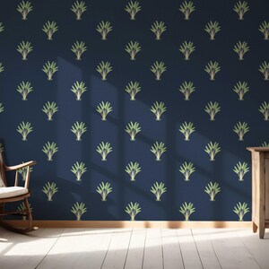 May include: A navy blue wall with a repeating pattern of stylized green and gold plant-like designs. A wooden rocking chair with a white cushion sits in front of a window. A wooden cabinet with a vase and fruit is on the right.