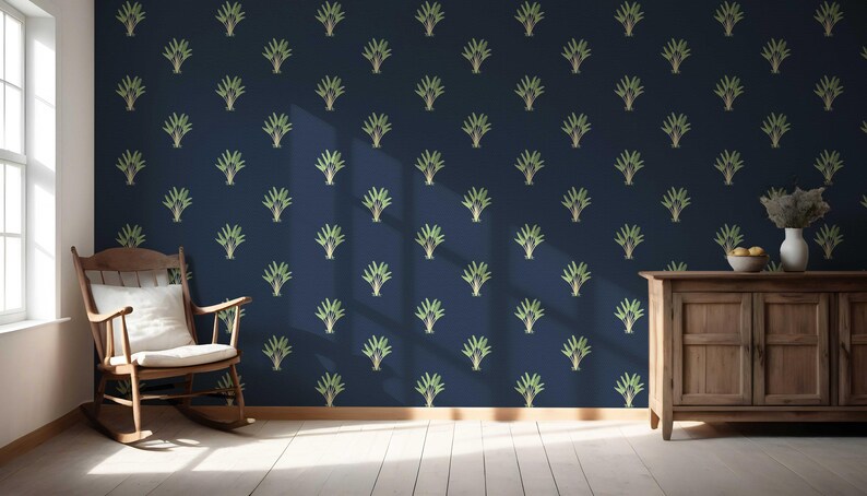 May include: A navy blue wall with a repeating pattern of stylized green and gold plant-like designs. A wooden rocking chair with a white cushion sits in front of a window. A wooden cabinet with a vase and fruit is on the right.