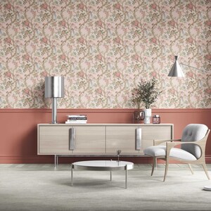 May include: A modern living room with floral wallpaper, a light wood cabinet, and a gray chair. A silver lamp and a floor lamp provide lighting. The room has a neutral color palette with accents of coral.