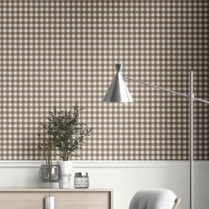 May include: A room with brown and cream checkered wallpaper. A silver lamp with a cone-shaped shade is positioned on the right. A wooden cabinet holds a vase with plants and a decorative jar. The room has a neutral color palette.