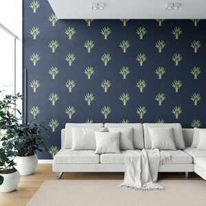 May include: A modern living room featuring a white sectional sofa, a beige rug, and potted plants. The navy blue wall is adorned with a repeating pattern of green and gold stylized plant motifs, creating a stylish backdrop.