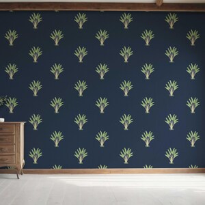 May include: A navy blue wall with a repeating pattern of stylized green and gold plant-like designs. A wooden dresser with a vase and decorative items sits in front of the wall. A window and wooden trim are visible.