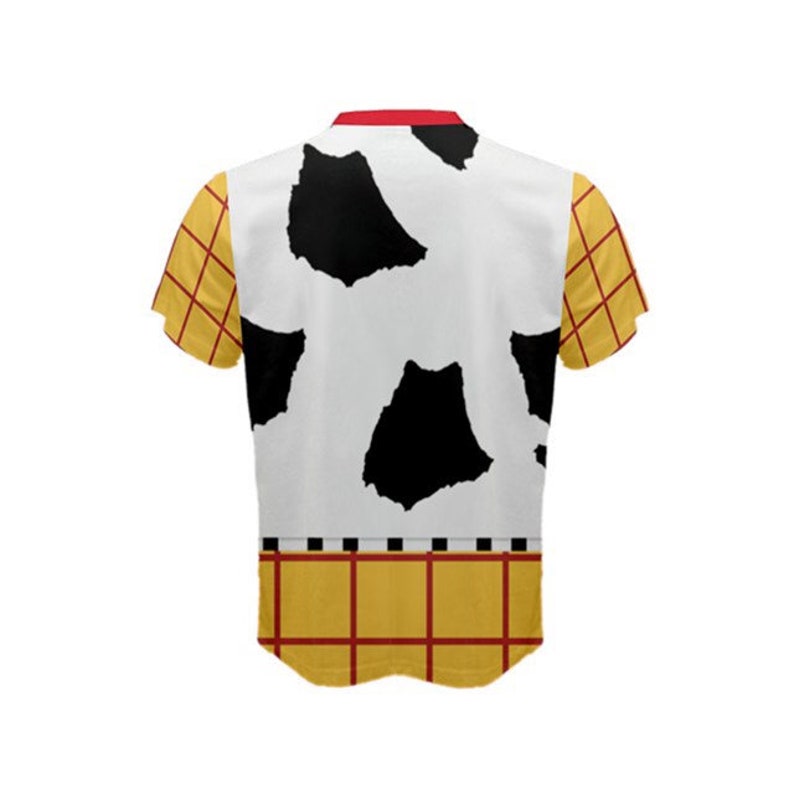 Puede incluir: Una camisa blanca de manga corta con un patr&oacute;n de vaca blanco y negro en la parte delantera y un patr&oacute;n de cuadros amarillo y rojo en las mangas y la parte inferior.