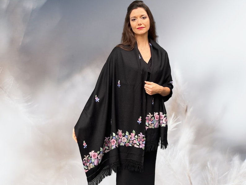 May include: A black shawl with a floral embroidery design. The shawl has a fringe border and is made of a soft, luxurious fabric.