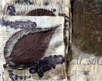 May include: A collection of handmade fabric squares with botanical prints. The natural-toned fabric features dark brown and purple leaf imprints, creating a rustic and artistic aesthetic. The edges are frayed, adding to the handmade charm.