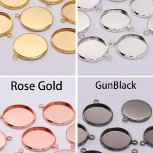 May include: Assortment of round metal pendant trays in gold, silver, rose gold, and gun black finishes. Each tray has a loop for hanging and a flat surface for adding embellishments.