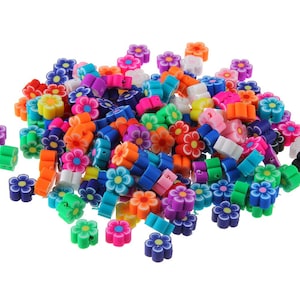 May include: A large pile of colorful flower-shaped polymer clay beads. The beads are in various shades of pink, blue, green, orange, yellow, and purple.