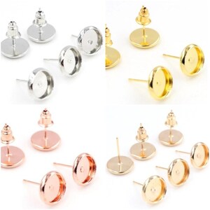 May include: Set of earring blanks in silver, gold, and rose gold. Each blank has a round bezel setting and a post with a butterfly backing.