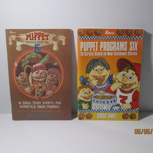 May include: Two vintage puppet program books with brown covers. The first book is titled "Puppet Programs No. 5" and features a colorful illustration of puppets. The second book is titled "Puppet Programs Six" and features a colorful illustration of puppets eating cookies. Both books are by Doug Smee.
