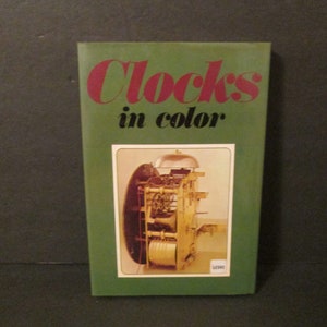 May include: A green book titled "Clocks in color" with a photo of a clock mechanism on the cover.