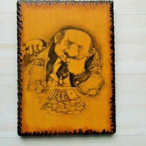 May include: A black and white drawing of a man playing cards. He is sitting at a table with a pile of chips in front of him. The drawing is on a yellow background with a brown wood frame.