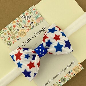 May include: A white headband with a red, white, and blue star patterned bow. The bow has a blue polka dot center. The headband is on a white card with the text "Jill Craft & Design" and "www.Etsy.com/shop/jlcraftdesign".