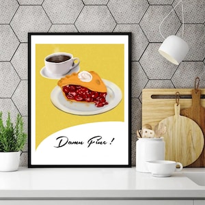 May include: Framed art print showing a slice of cherry pie with cream, a coffee cup, and the text "Damn Fine!" on a yellow backdrop. The print is in a black frame, suitable for a kitchen.
