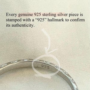 May include: Close-up of a silver ring with a textured design. The ring is stamped with "925" to confirm its authenticity. The text in the image states that every genuine 925 sterling silver piece is stamped with a "925" hallmark.