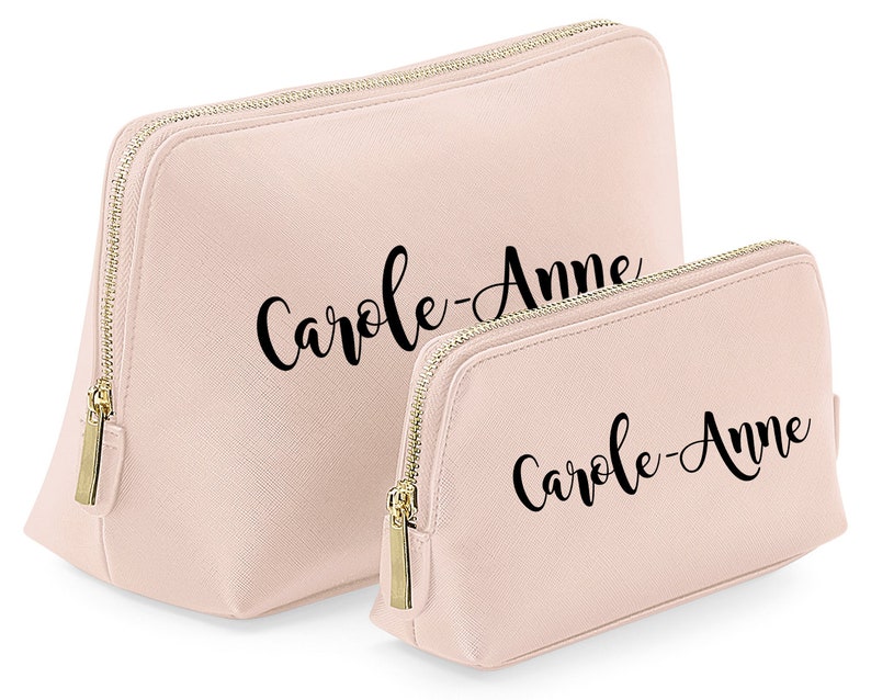 May include: Two pink zippered makeup bags with the name "Carole-Anne" printed in black cursive on each bag.