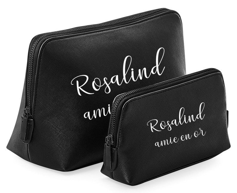 May include: Two black cosmetic bags with white text. The larger bag has the name "Rosalind" and the smaller bag has the name "Rosalind" and the phrase "amie en or". Both bags have a zipper closure.