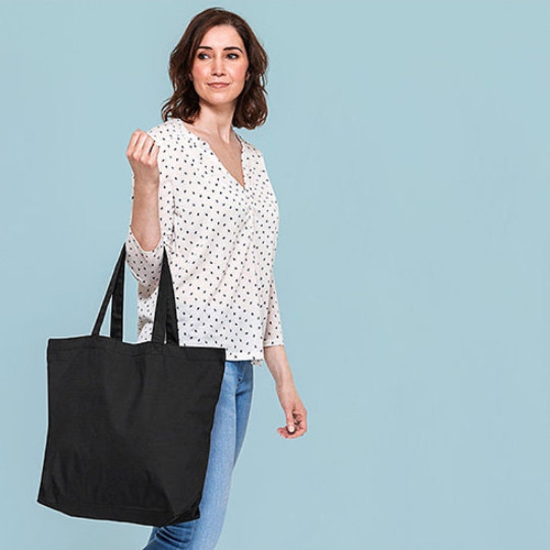 May include: A black tote bag with two handles. The bag is made of canvas and has a large capacity.