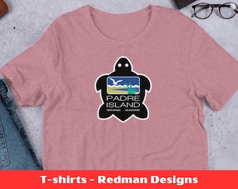 May include: A pink t-shirt with a black sea turtle graphic. The turtle has a green and blue shell with a white bird flying over it. The text "Padre Island National Seashore" is printed on the turtle's shell.