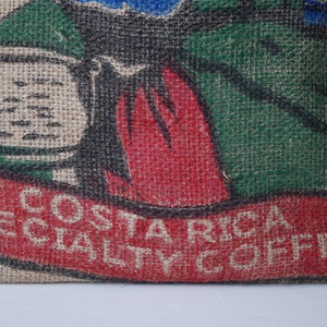 May include: A burlap sack with a red, green, and black design. The sack has the text "COSTA RICA SPECIALTY COFFEE" printed on it.
