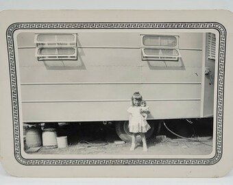 Vintage Foto des netten kleinen Mädchens, das ihre Puppe - Anhänger im Hintergrund hält ~1950