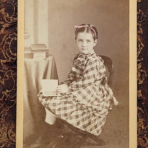 Kokarda do włosów dla małej dziewczynki w kolorze różowym~Zdjęcie CDV~Krzesełko dla dziewczynki siedzącej z boku~Fototeka w ręku