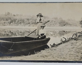 Zwei Frauen im Ruderboot ~ RPPC ~ Eine steht mit Ruder ~ trägt edwardianische Hüte ~ Wasserspiegelung