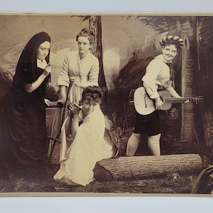 Imagen peculiar escenificada ~ Mujer vestida de monja, otra drag con guitarra y bigote ~ Foto de tarjeta de gabinete