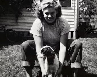 Mujer con perro joven, instantánea vintage, perro mestizo de spaniel, vaqueros con puños