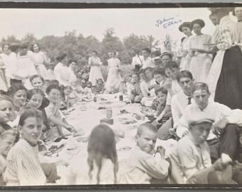 Grand pique-nique champêtre sur une couverture RPPC Grand groupe d'hommes, de femmes et d'enfants