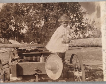 1907 Niño en maquinaria agrícola RPPC Lata de aceite, sombrero de paja, nota corta Wilber, NE
