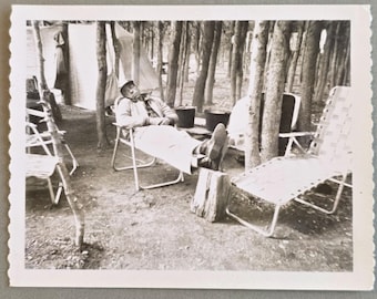 Hombre durmiendo la siesta en un camping. Foto Polaroid vintage. Tienda de campaña y sillas de jardín.
