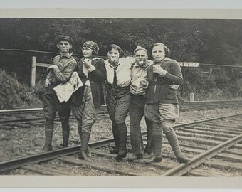 Eisenbahnschienen~Gruppe von Freunden~Deko-Ära-Foto~Lustige Posen beim Äpfelessen