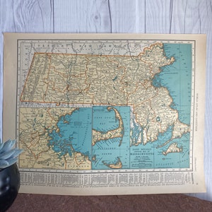 Könnte beinhalten: Eine Vintage-Karte von Massachusetts mit einem blauen und grünen Farbschema. Die Karte zeigt die Countys, Städte und Gemeinden des Bundesstaates. Die Karte enthält auch einen Schlüssel mit Informationen über die Geographie und Geschichte des Bundesstaates. Die Karte trägt den Titel "Rand McNally Popular Map of Massachusetts".